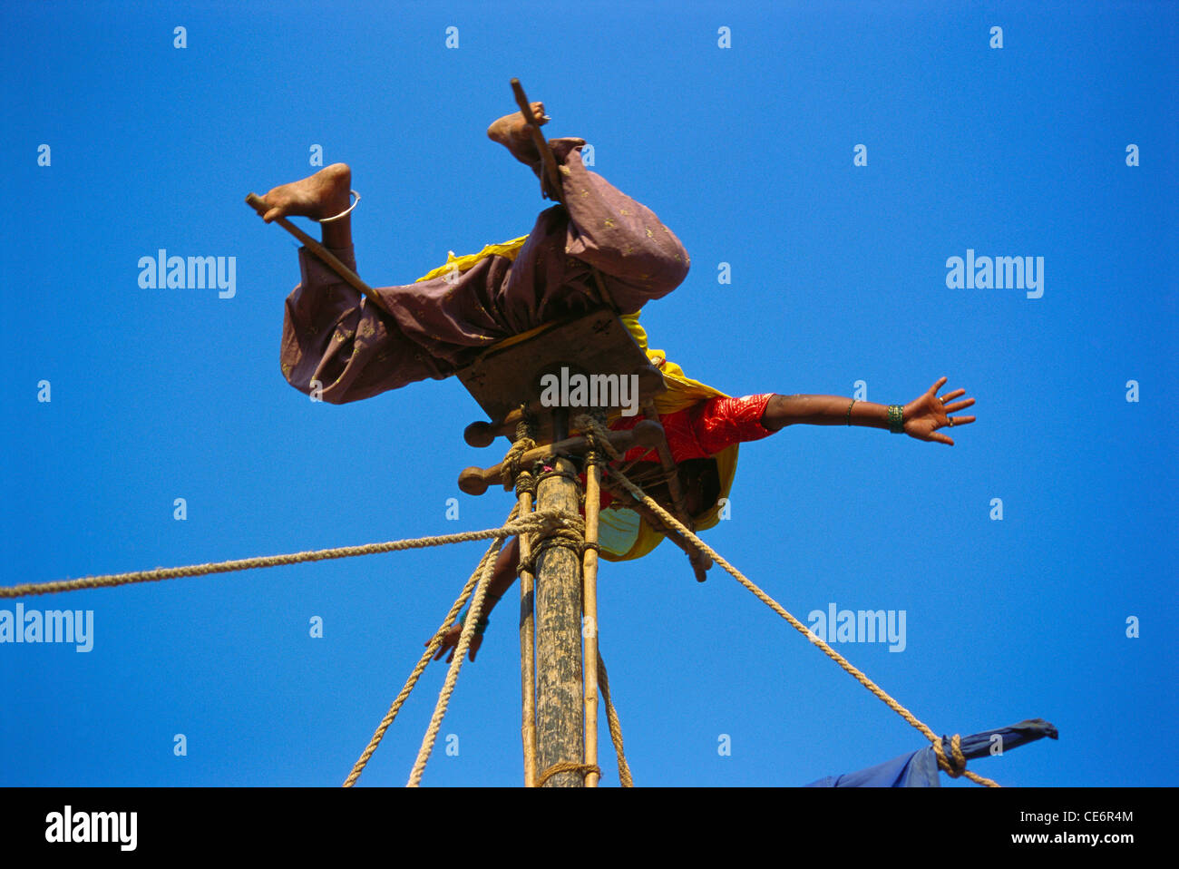 Donna rurale indiana strada acrobat gymnast equilibratura sulla cima di palo di legno ; india ; asia Foto Stock