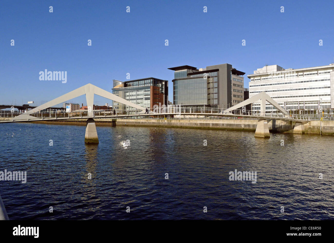 Un line-up di edifici su entrambi i lati del pedone Tradeston ponte lungo Atlantic Quay sul fiume Clyde a Glasgow Foto Stock
