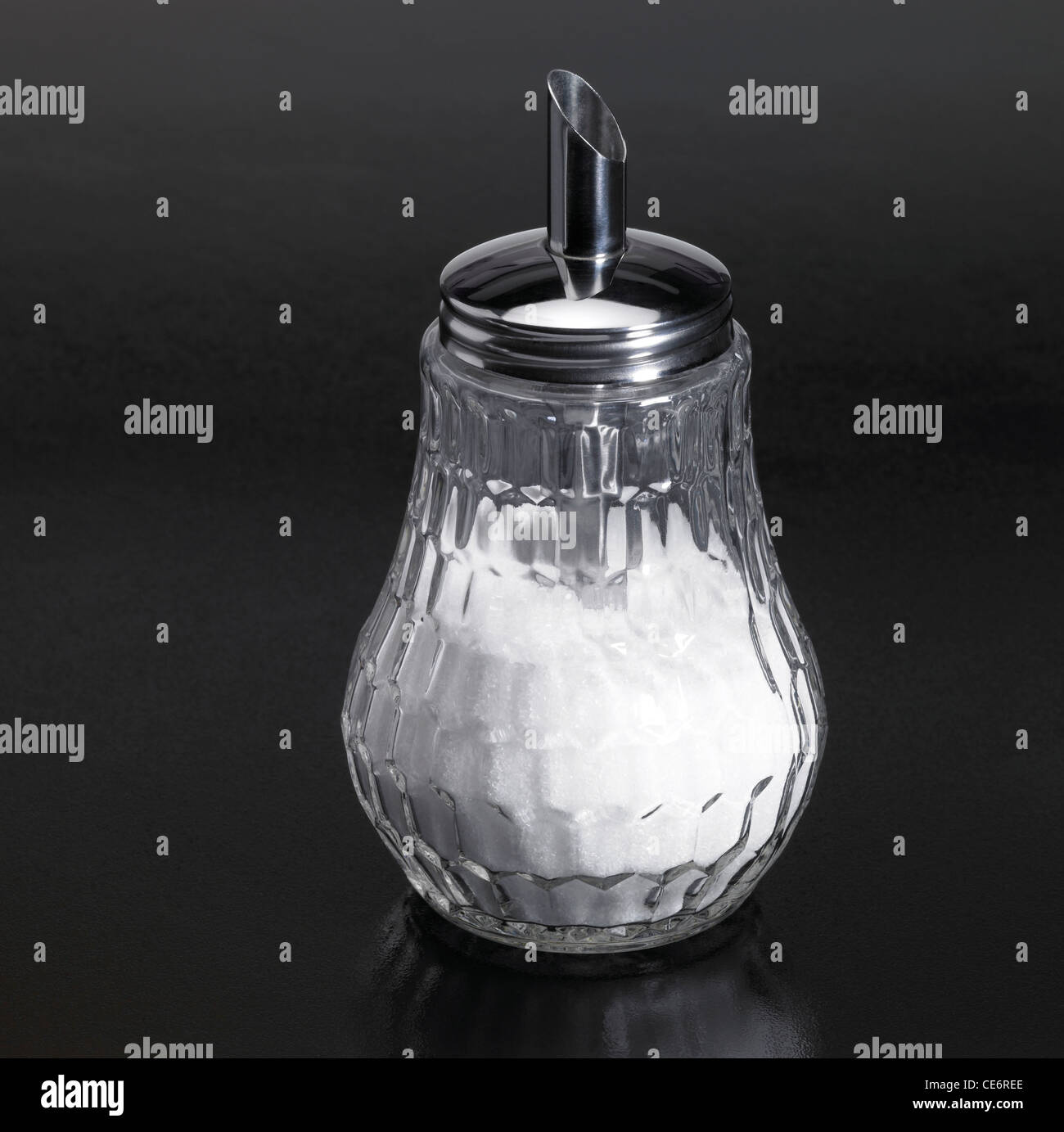 Studio fotografico di un irroratore di zucchero realizzata in vetro e metallo in scuro retro riflettente Foto Stock