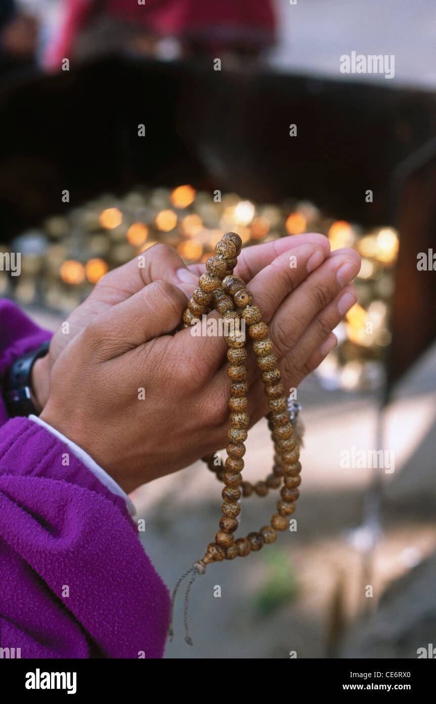 HMA 87804 : mano che tiene il salmodiare mala rosario tempio syambhunath Kathmandu in Nepal Foto Stock