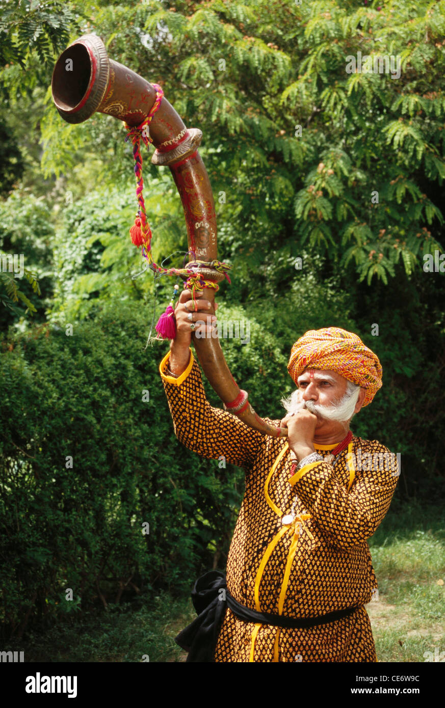 Rajasthani indiano vecchio uomo di musica folk per suonare uno strumento musicale lunga tromba Jaipur India Rajasthan Modello di Rilascio # 657 Foto Stock