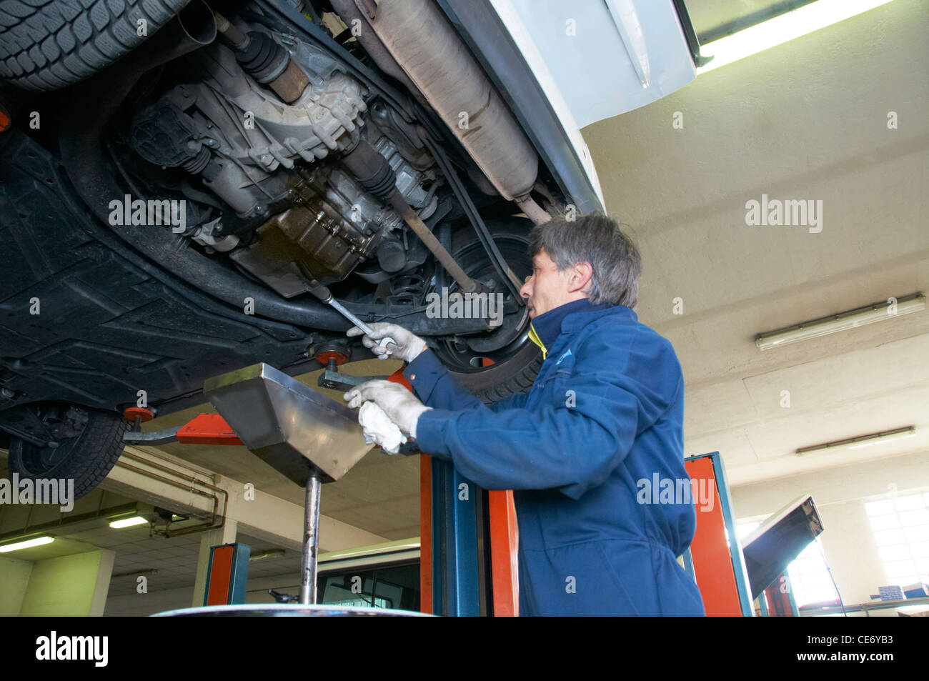 Meccanico ripara una vettura in un garage Foto Stock