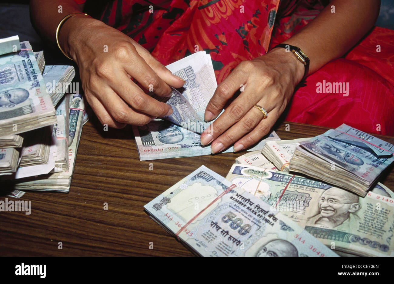 Donna indiana che conta i soldi a mano ; india ; asia Foto Stock
