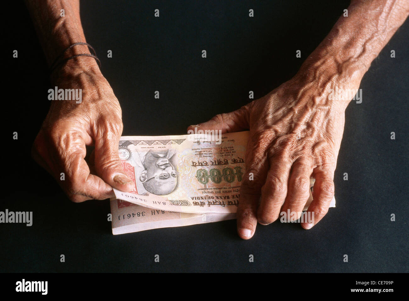 Vecchia donna conteggio carta moneta 1000 mille rupie indiane note Foto Stock