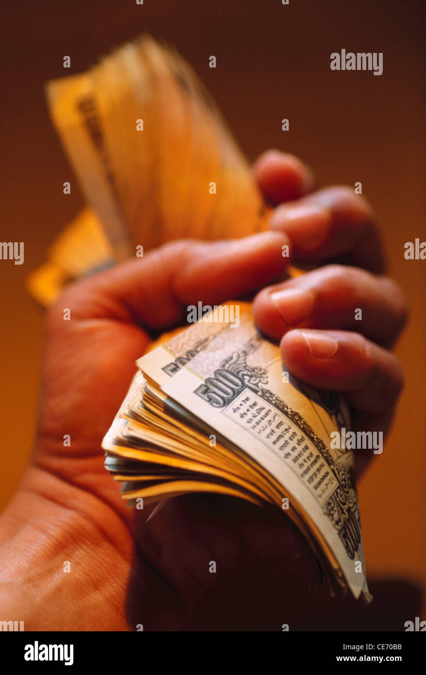 NVM 83937 : man holding stringendo la carta moneta rupie indiane 500 cinquecento note india Foto Stock