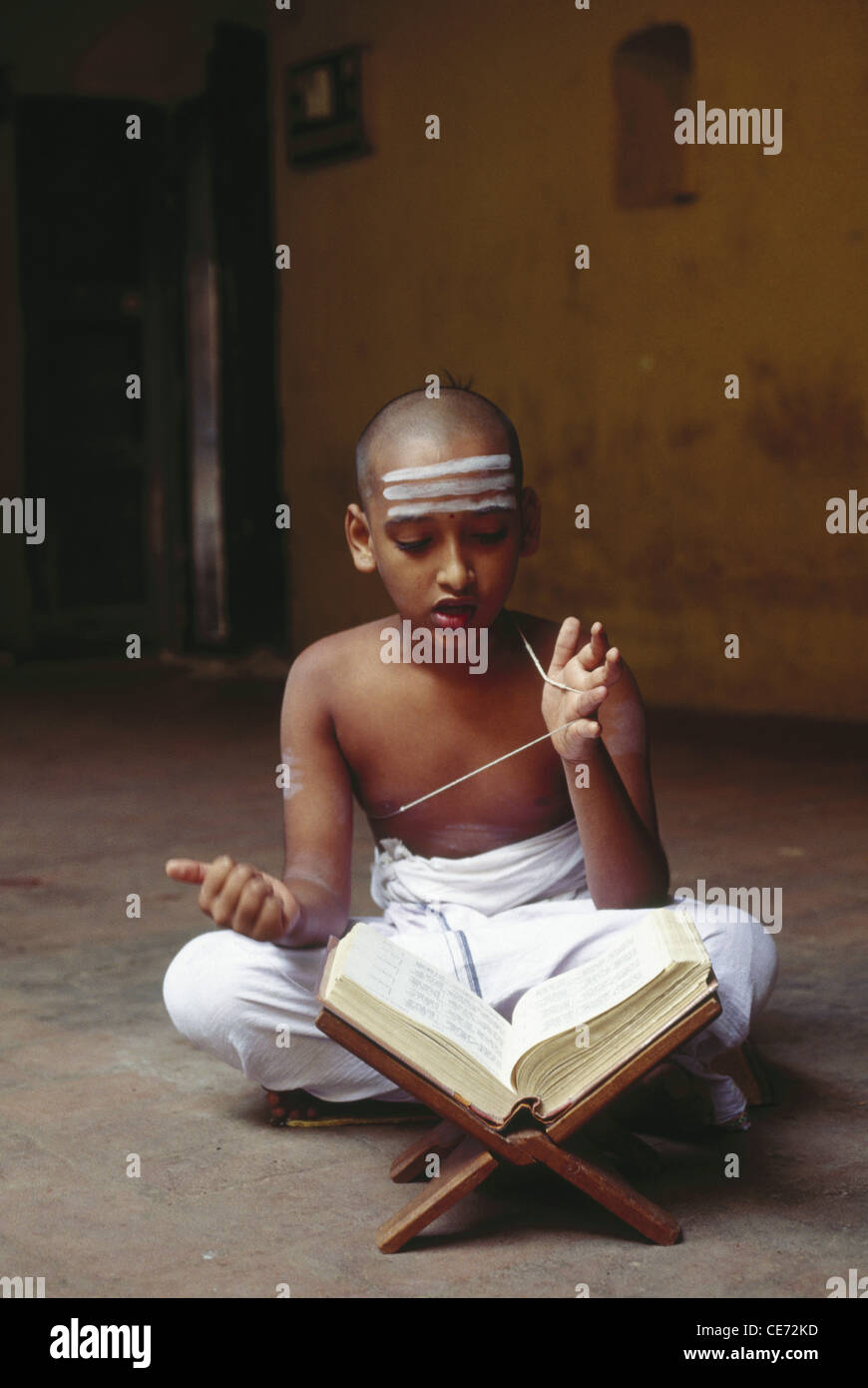 Ragazzo indù reciting Vedas, Scrittura indù, indosso filo sacro, contrassegni della fronte, Kumbakonam, Tamil Nadu, India, Asia Foto Stock