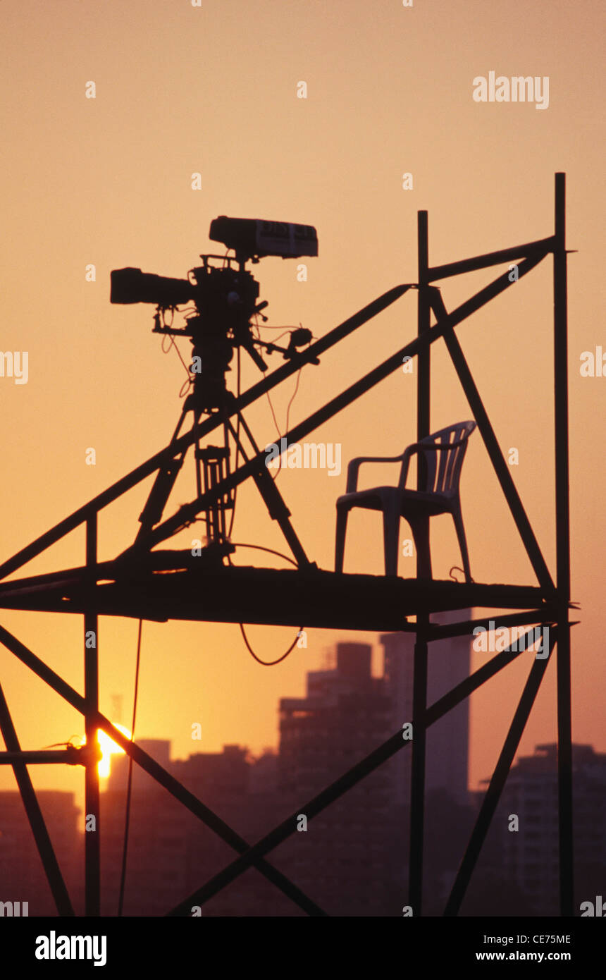 Telecamera per film su treppiede e sedia su piattaforma in silhouette ; bombay ; mumbai ; Maharashtra ; india ; asia Foto Stock