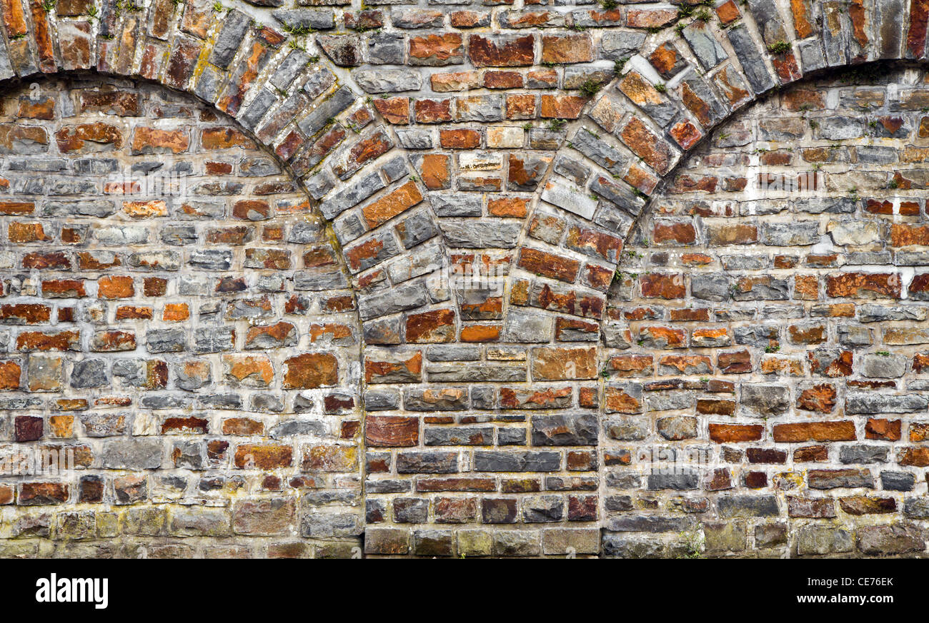 Vecchi mattoni stonewall da tagliare rocce con arcate in mattoni Foto Stock