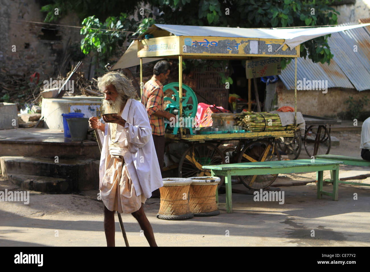 Indian uomo pellegrino alla canna da zucchero succo di frutta in stallo. Rajasthan in India Foto Stock