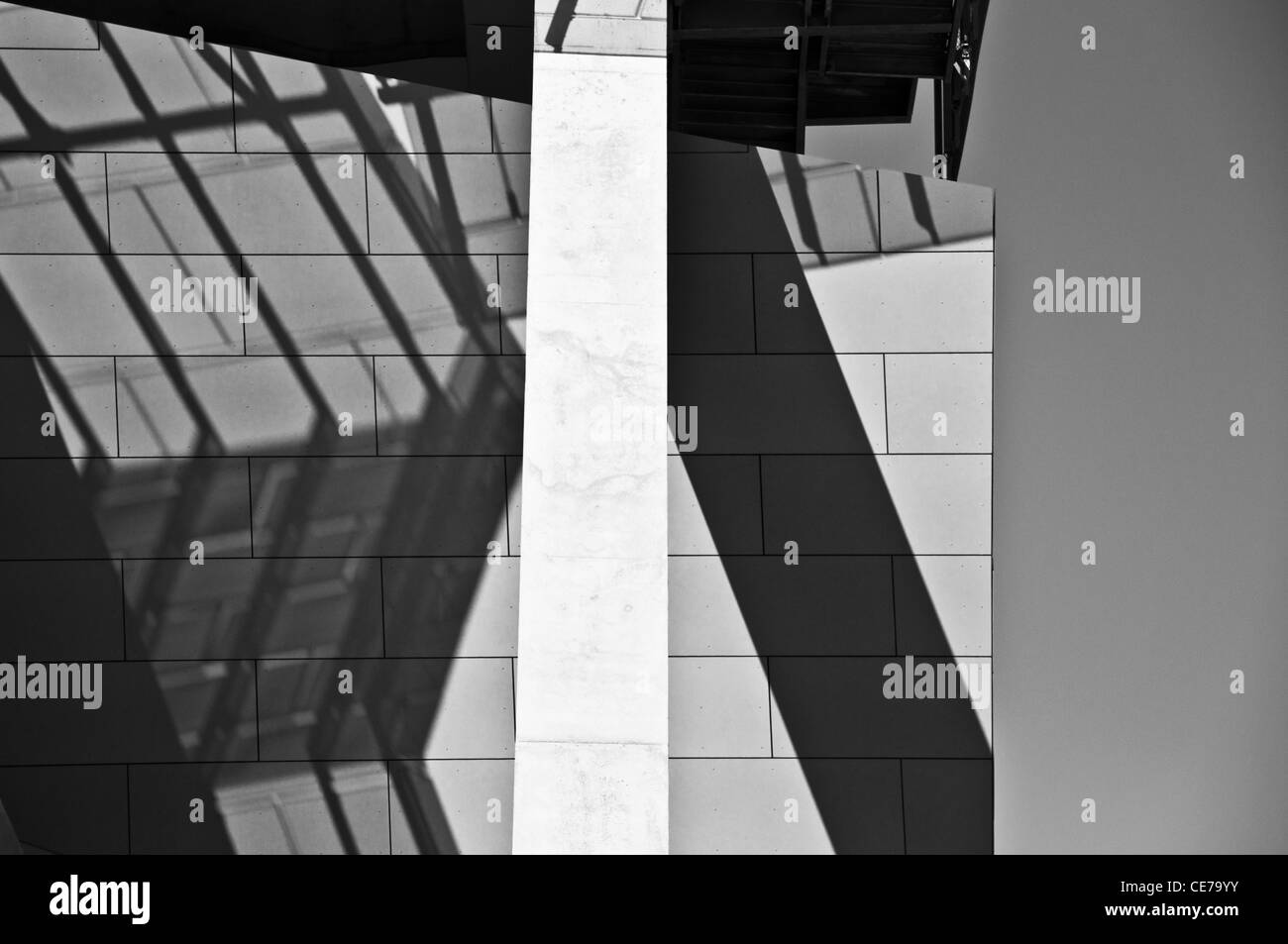 Fotografia in bianco e nero di un pattern di ombra cadere sulla città moderna costruzione in presenza di intensa luce solare Foto Stock