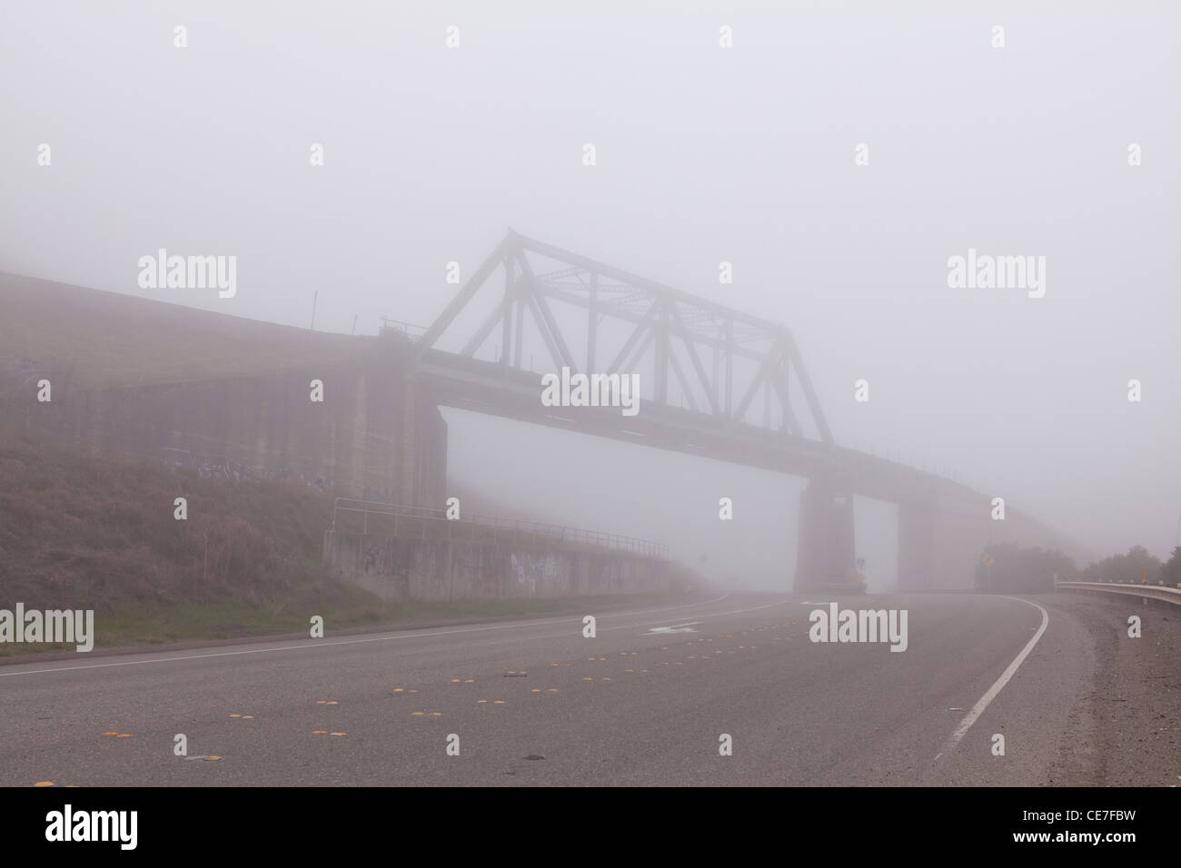 Sovrappasso ferroviario su una mattinata nebbiosa Foto Stock