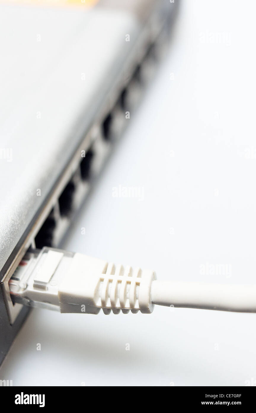 Hub di rete switch con cavo LAN connesso su bianco Foto Stock