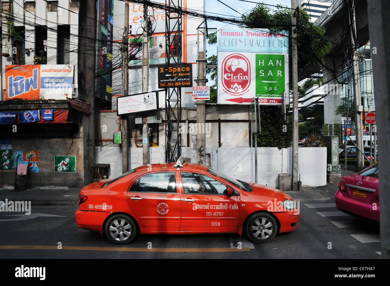 Taxi rosso allo svincolo in Sukhumvit Road, Bangkok, Thailandia Foto Stock