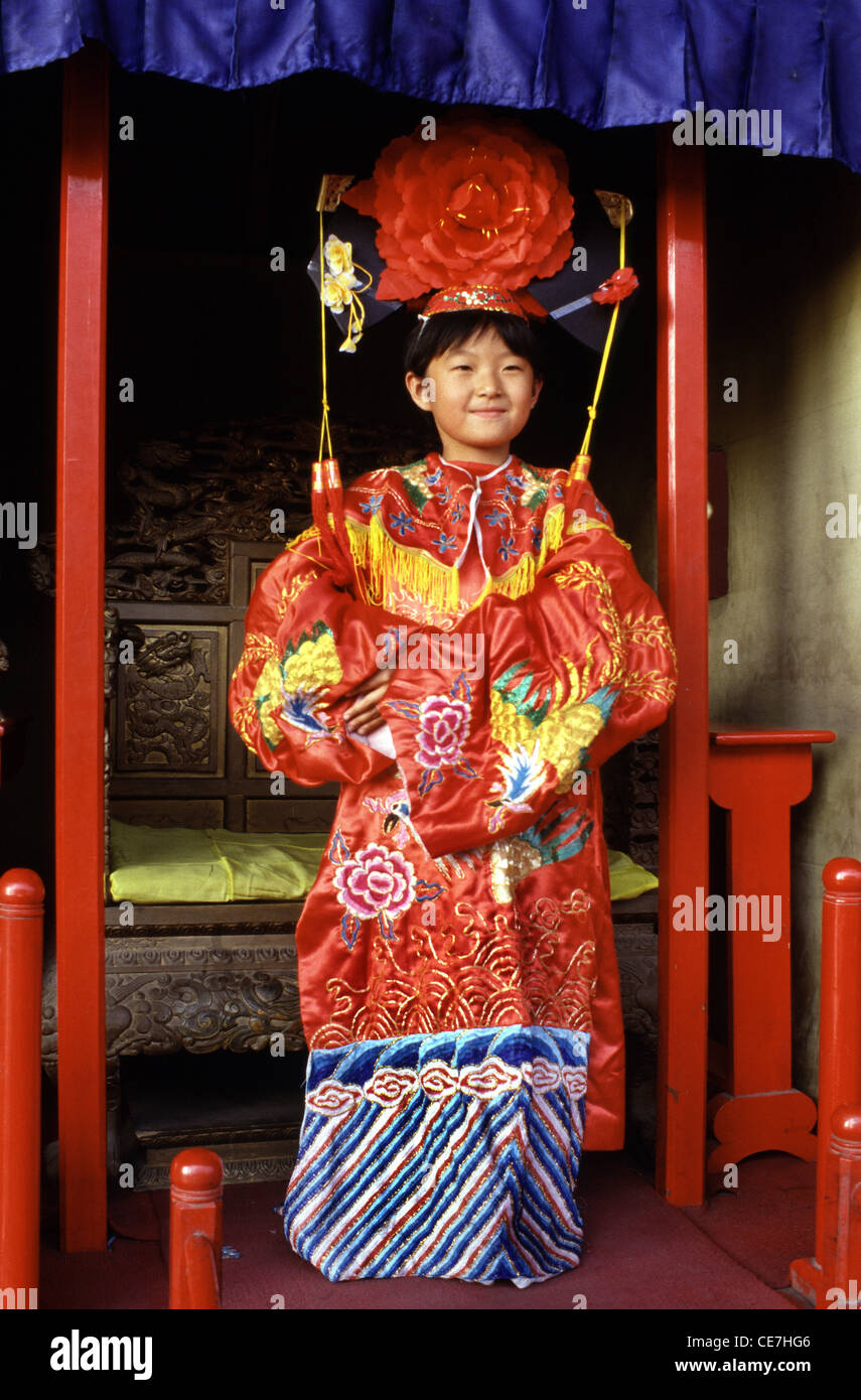 La giovane ragazza cinese indossa un costume da sposa in stile dinastia Qing noleggiato mentre si visita il Tiantan Park in Cina di Pechino Foto Stock