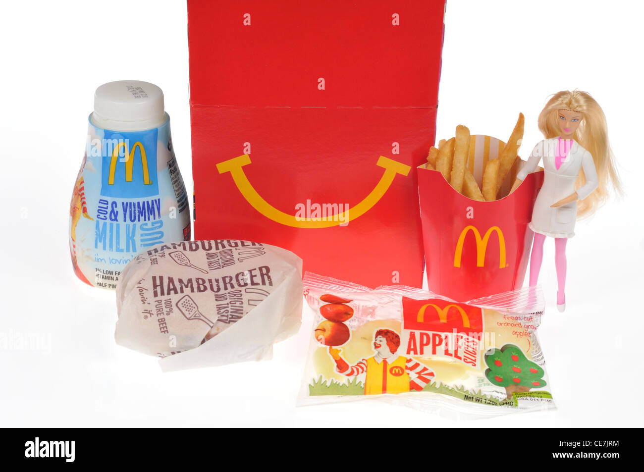 McDoanld's Happy Meal con un hamburger, patatine fritte, latte e apple campionatori a immersione e una bambola Barbie giocattolo su sfondo bianco, intaglio, Foto Stock