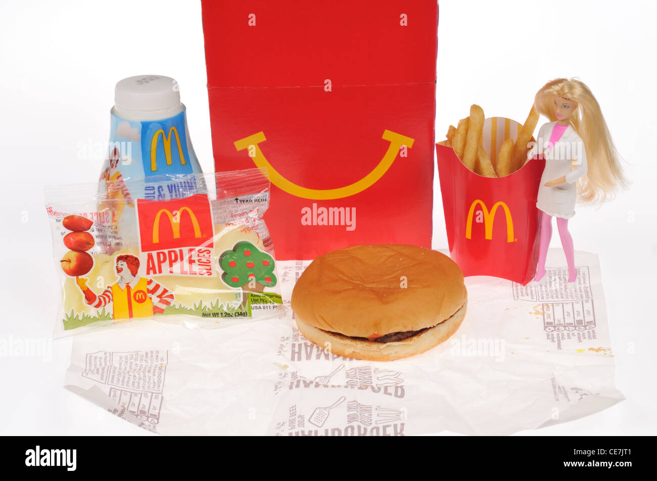McDoanld ragazze del pasto felice con un hamburger, patatine fritte, latte e apple campionatori a immersione, una bambola Barbie toy & box su sfondo bianco, intaglio, Foto Stock