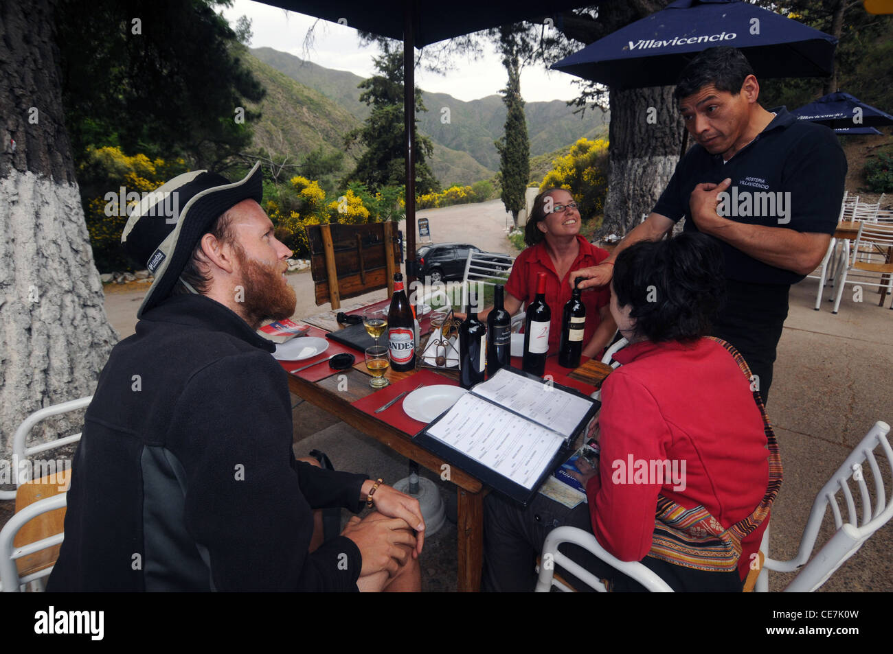 Cameriere e turisti a discutere di vino e cibo menu a Villavicencio, Argentina. No signor o PR Foto Stock