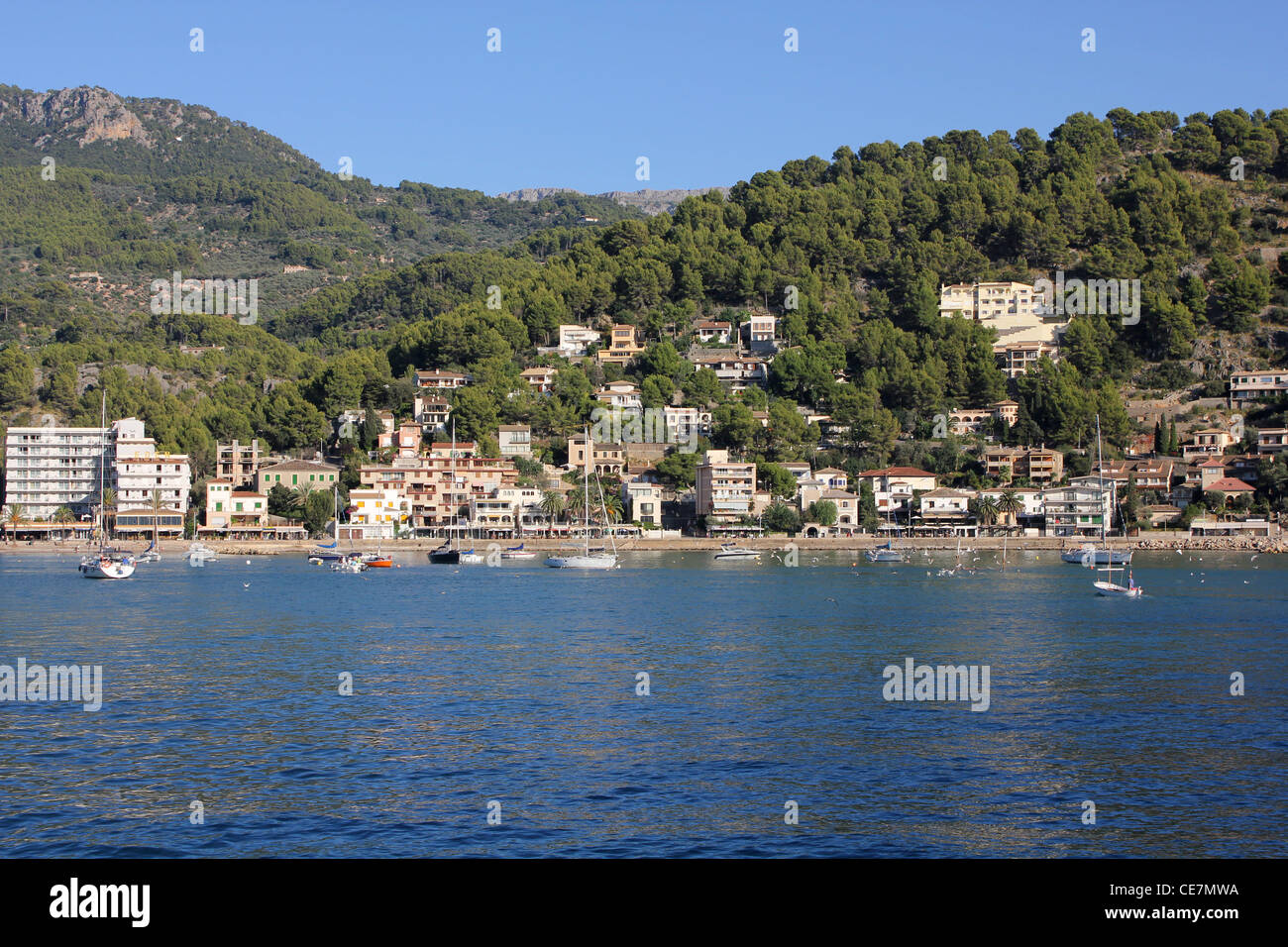 Scena - con barche ancorate, la spiaggia e le colline boscose circostante Puerto Soller / Porto di Soller, a nord ovest di Mallorca / Maiorca Foto Stock