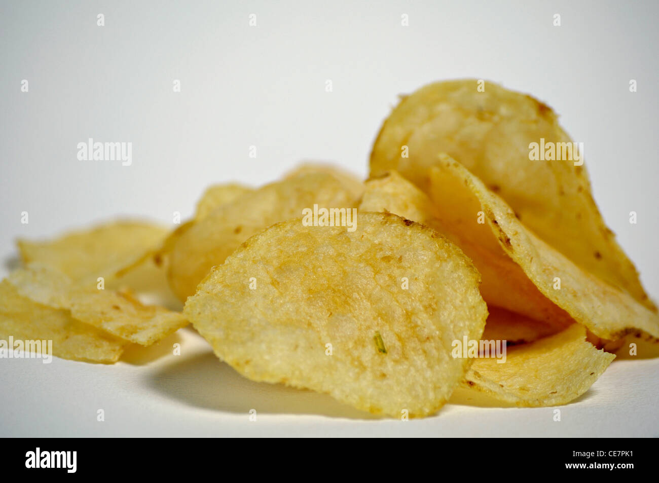 Un mucchio di pianura potato chips siede su uno sfondo semplice. Foto Stock