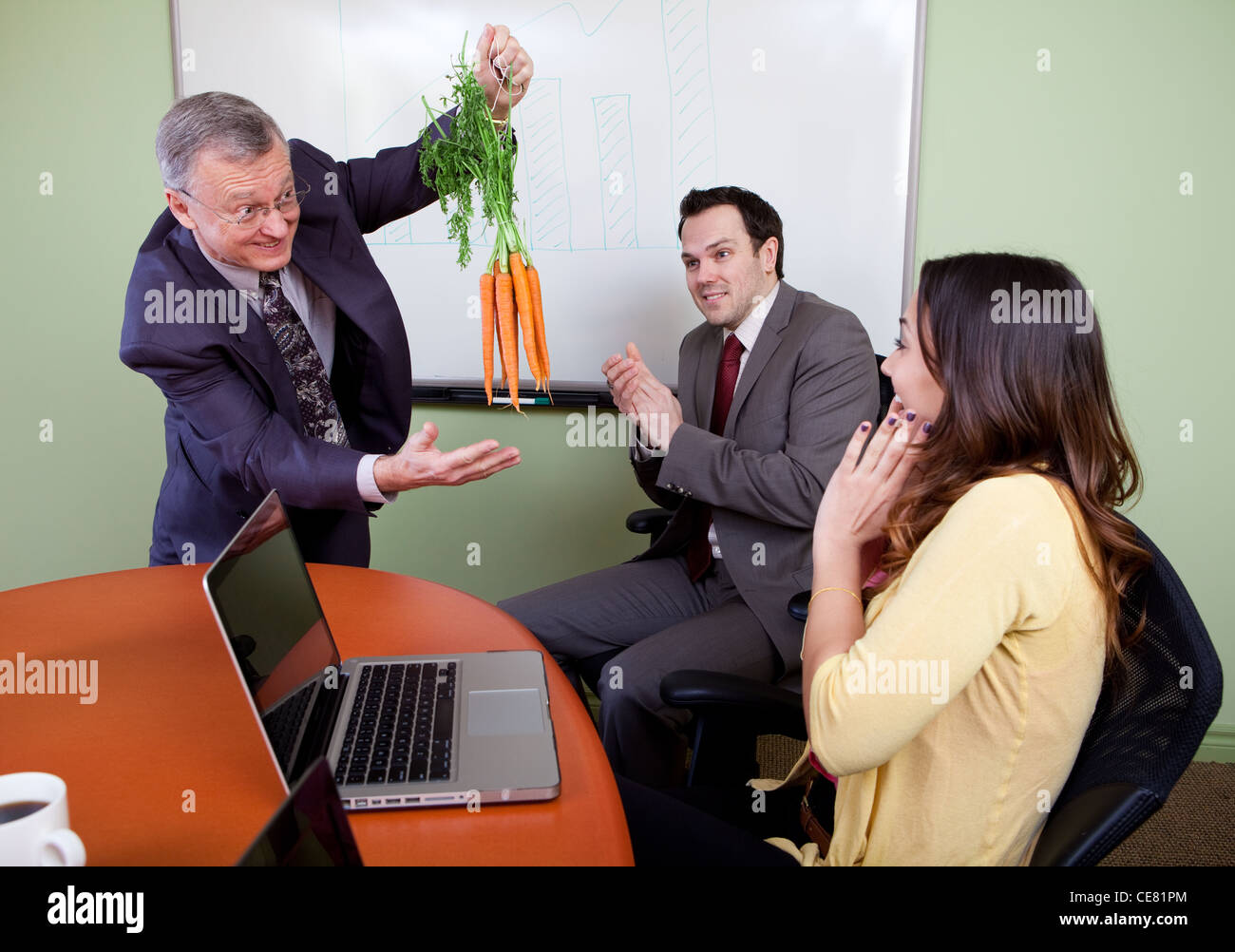 Il grande motivatore carote penzolanti e Business team motivato dal presentatore positivo Foto Stock