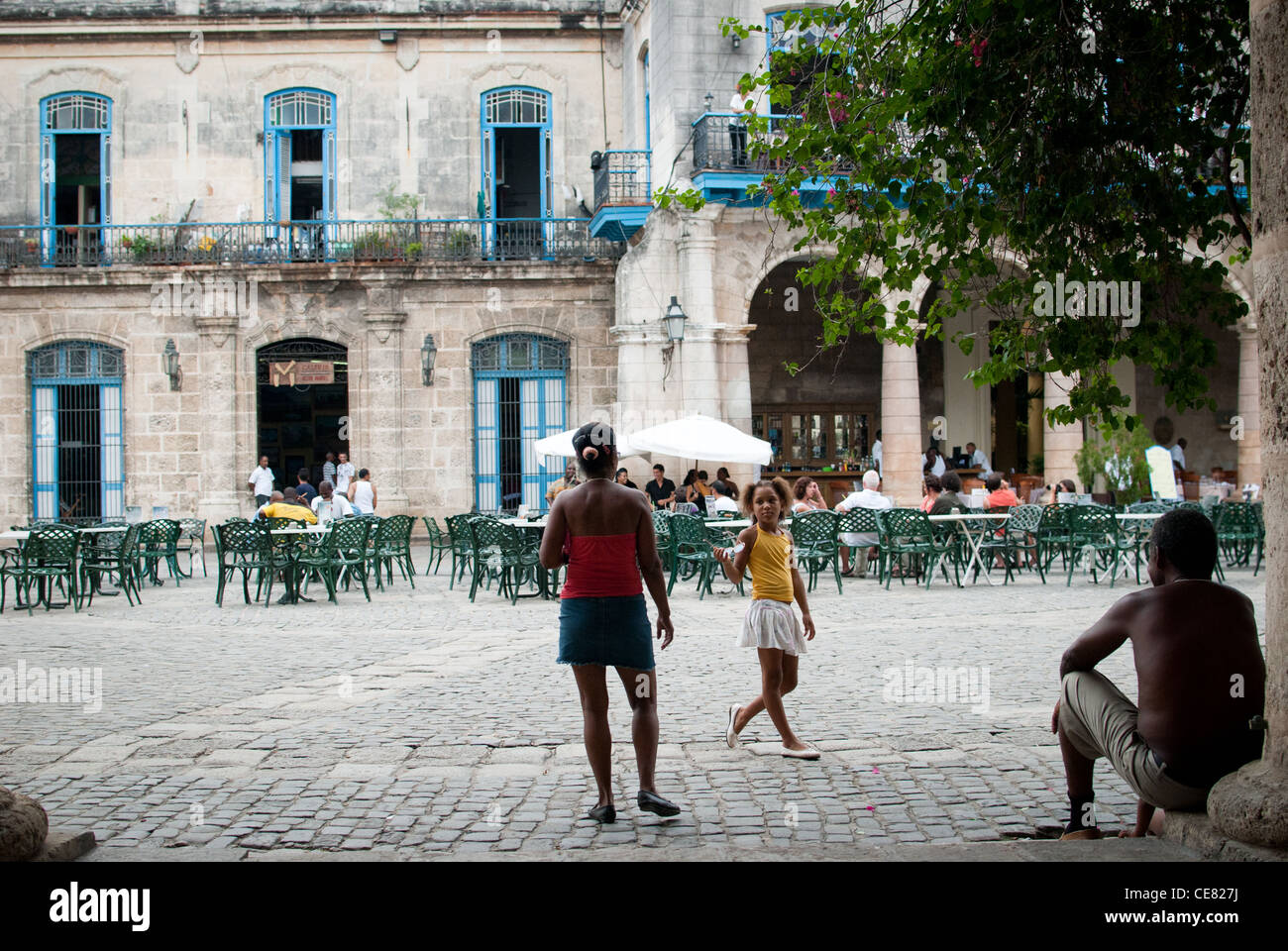 Famiglia cubana godendo l'ombra e la musica dal vivo in Plaza De La Catedral, Havana, Cuba Foto Stock