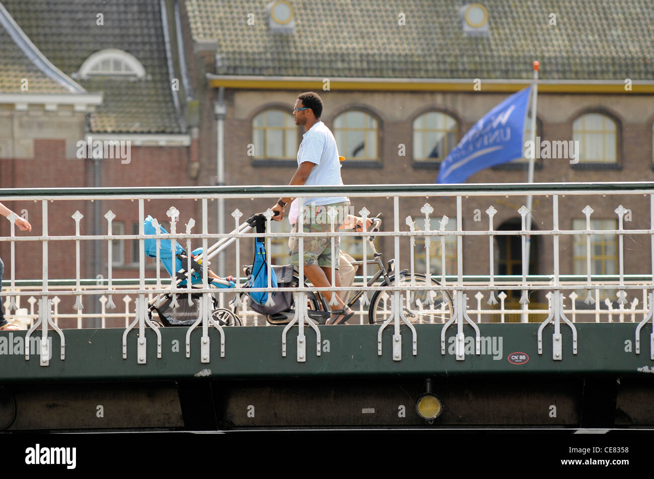 L'uomo spinge il bambino nel passeggino su un ponte in Leiden, Olanda. Foto Stock