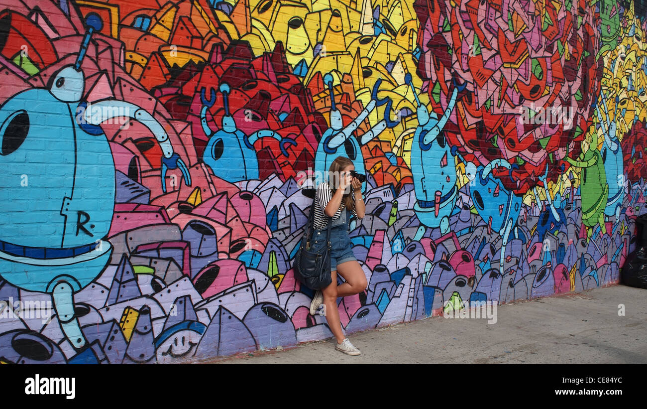 Giovane donna turista nella parte anteriore del robot murale, Brooklyn, New York Foto Stock