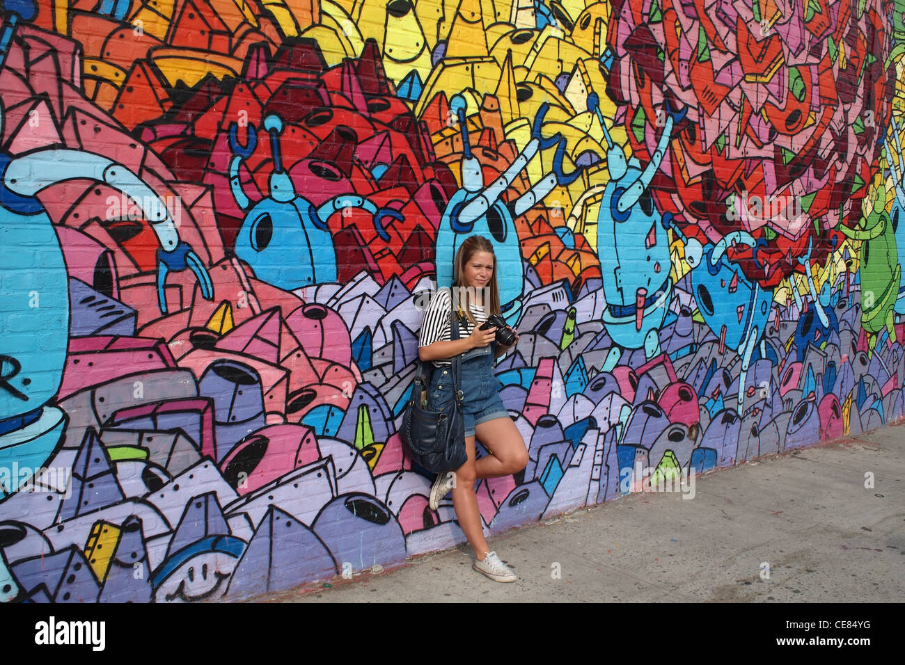 Giovane donna turista nella parte anteriore del robot murale, Brooklyn, New York Foto Stock