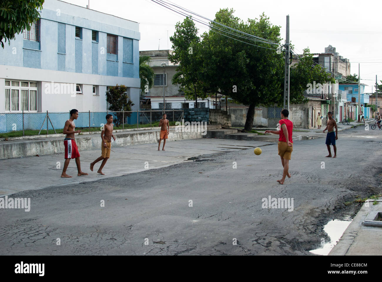 Ragazzi che giocano a calcio su una strada, Cienfuegos, Cuba Foto Stock