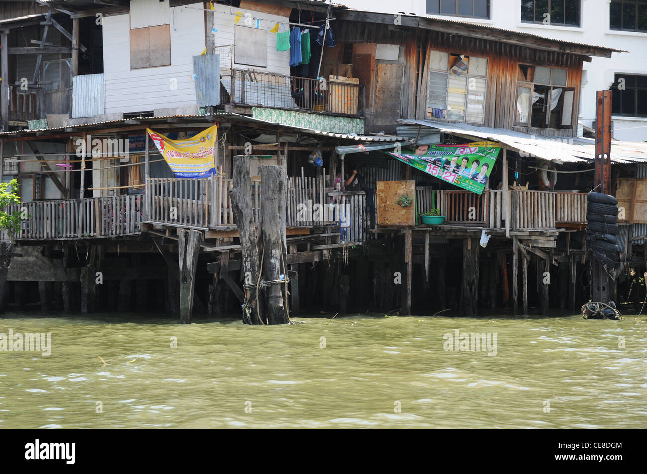 Fatiscenti, baracche di legno, alloggiamento su palafitte sulla del Fiume Chao Praya, Bangkok, Thailandia Foto Stock