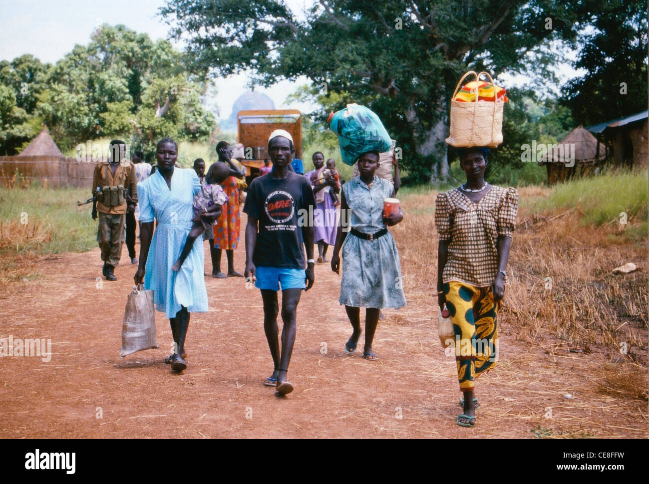 Abitanti di villaggi sudanesi nel sud Sudan, Africa che trasportano gli oggetti di nuovo da un mercato Foto Stock
