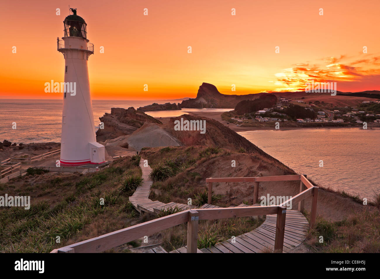 Tramonto a Castlepoint faro che si affaccia sulla laguna e bay, Castlepoint, Wairarapa, Isola del nord, Nuova Zelanda. Foto Stock