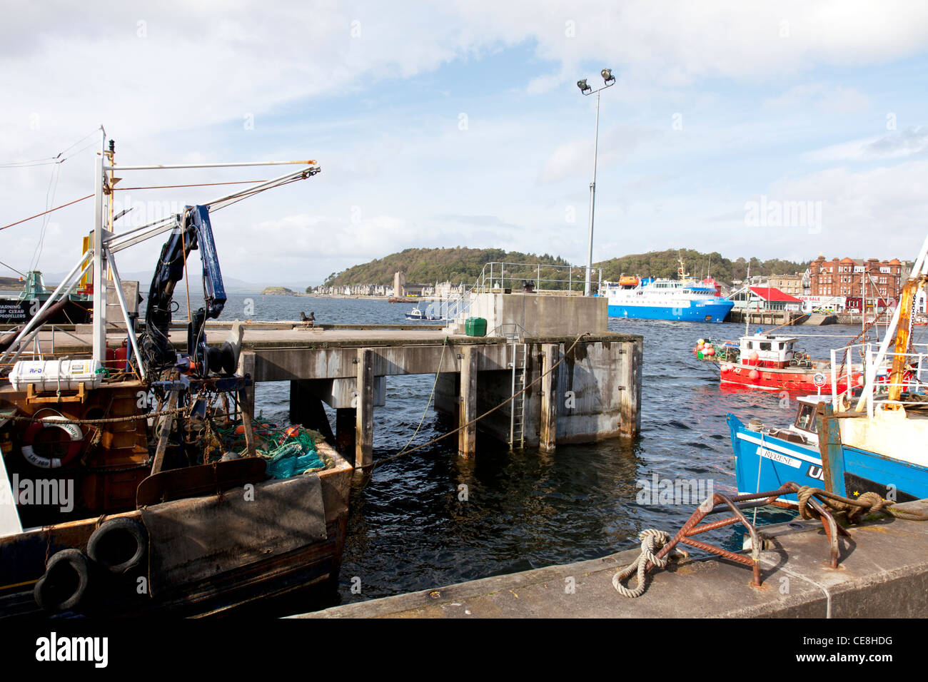 Oban, nella costa occidentale della Scozia, Regno Unito mare porto anteriore parete e negozi della città e la pesca in barca Foto Stock