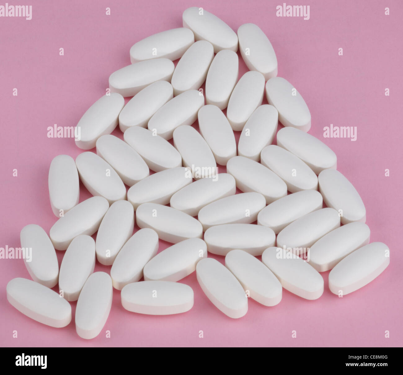 Pillola bianco su sfondo rosa Foto Stock