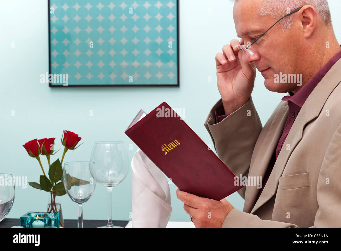 Foto di un uomo che legge il menu in un ristorante Foto Stock