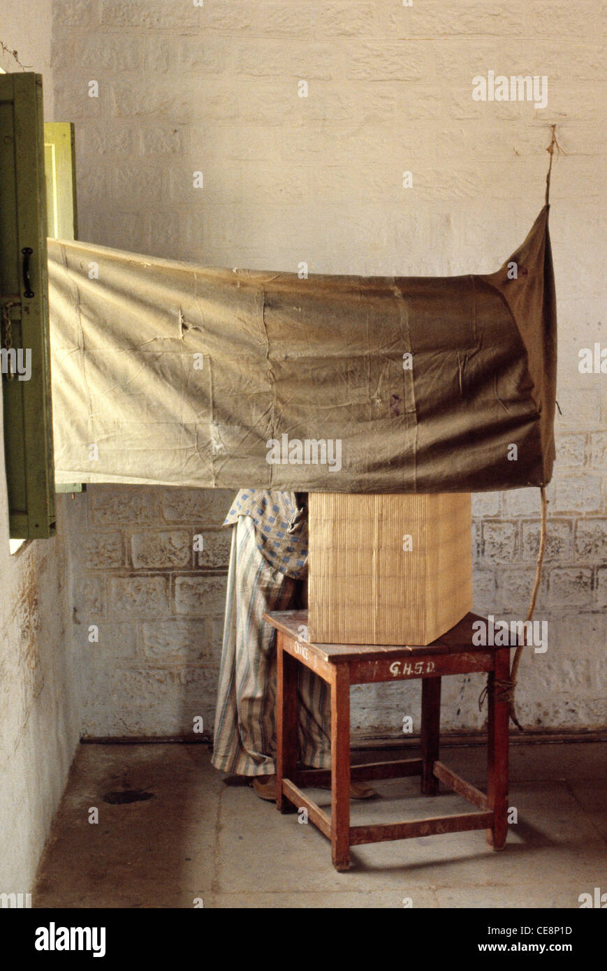 Indiano voto uomo dietro la cortina in villaggio Dunera Pincode postale 145022 nel Punjab India 1980 Foto Stock