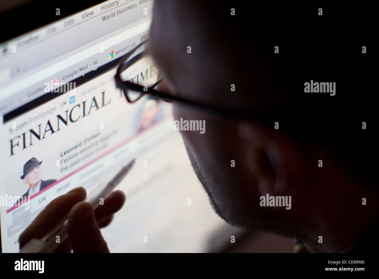Uomo che legge la versione web online del sito web online del Financial Times sullo schermo Foto Stock