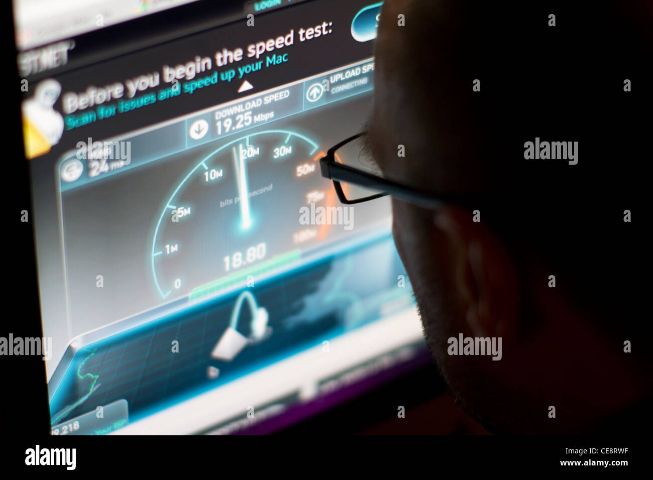 Maschio che guarda lo schermo con test di velocità a banda larga online, mostrando i risultati del test di velocità della connessione Internet Foto Stock