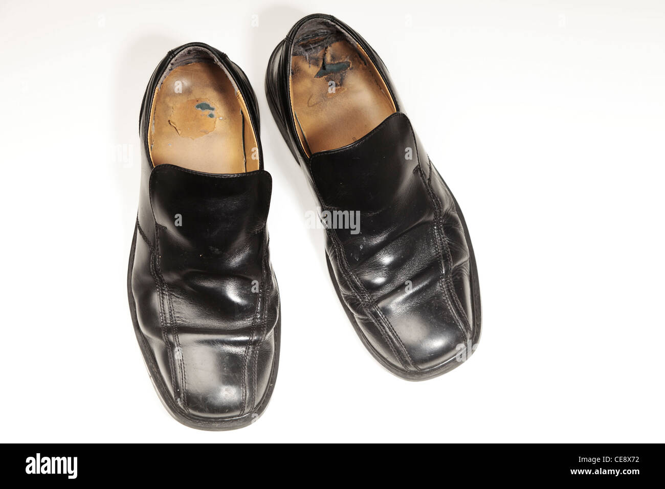 Coppia di vecchi e consunti gents nero scarpe fotografato su bianco Foto Stock