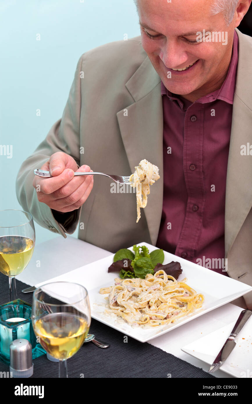 Foto di un uomo di mangiare la pasta in un ristorante italiano. Foto Stock