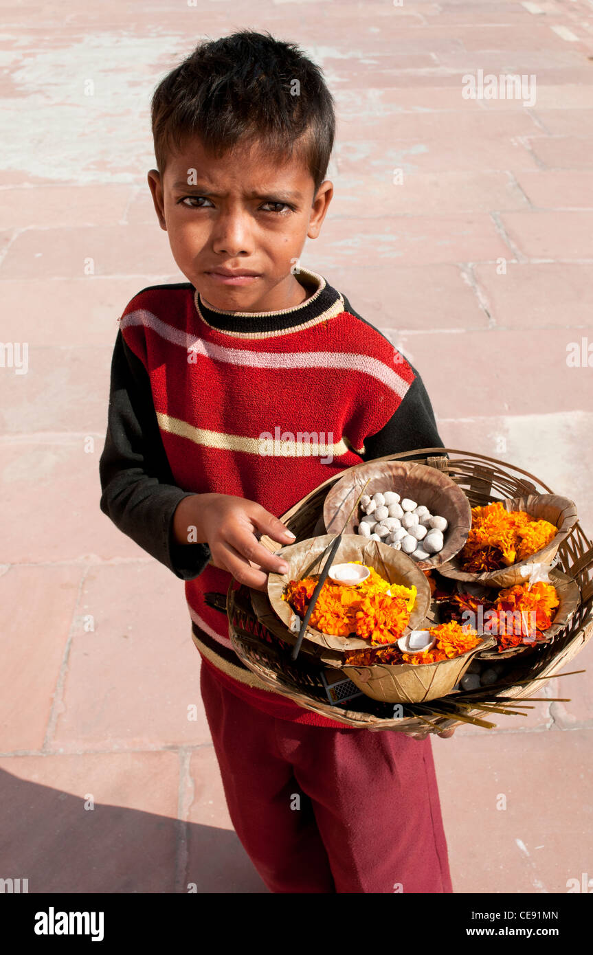 Ragazzo di vendita, diyas (fiore galleggia), piccoli contenitori con fiori e chapati pane per una puja, Rishikesh, Uttarakhand, India Foto Stock