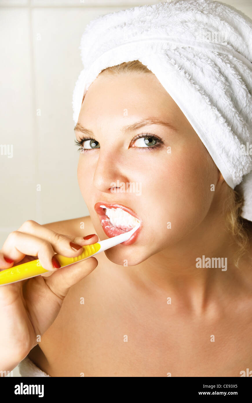 Bella ragazza sognante spazzolare i denti in bagno Foto Stock
