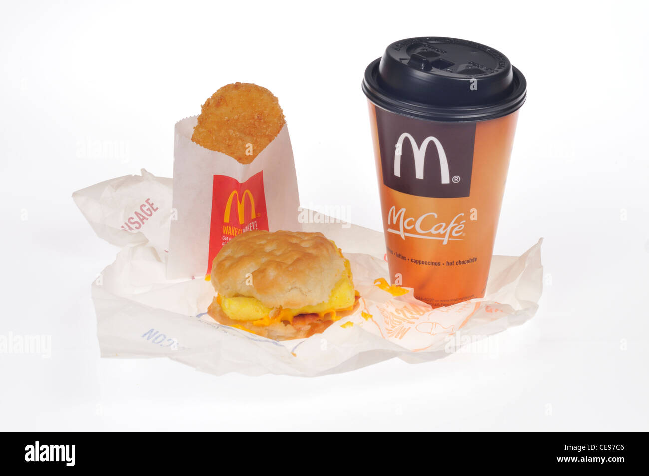 McDonalds prima colazione di bacon uova e formaggio biscotto sandwich, hash brown patate e caffè McCafe su sfondo bianco tagliato fuori. Foto Stock