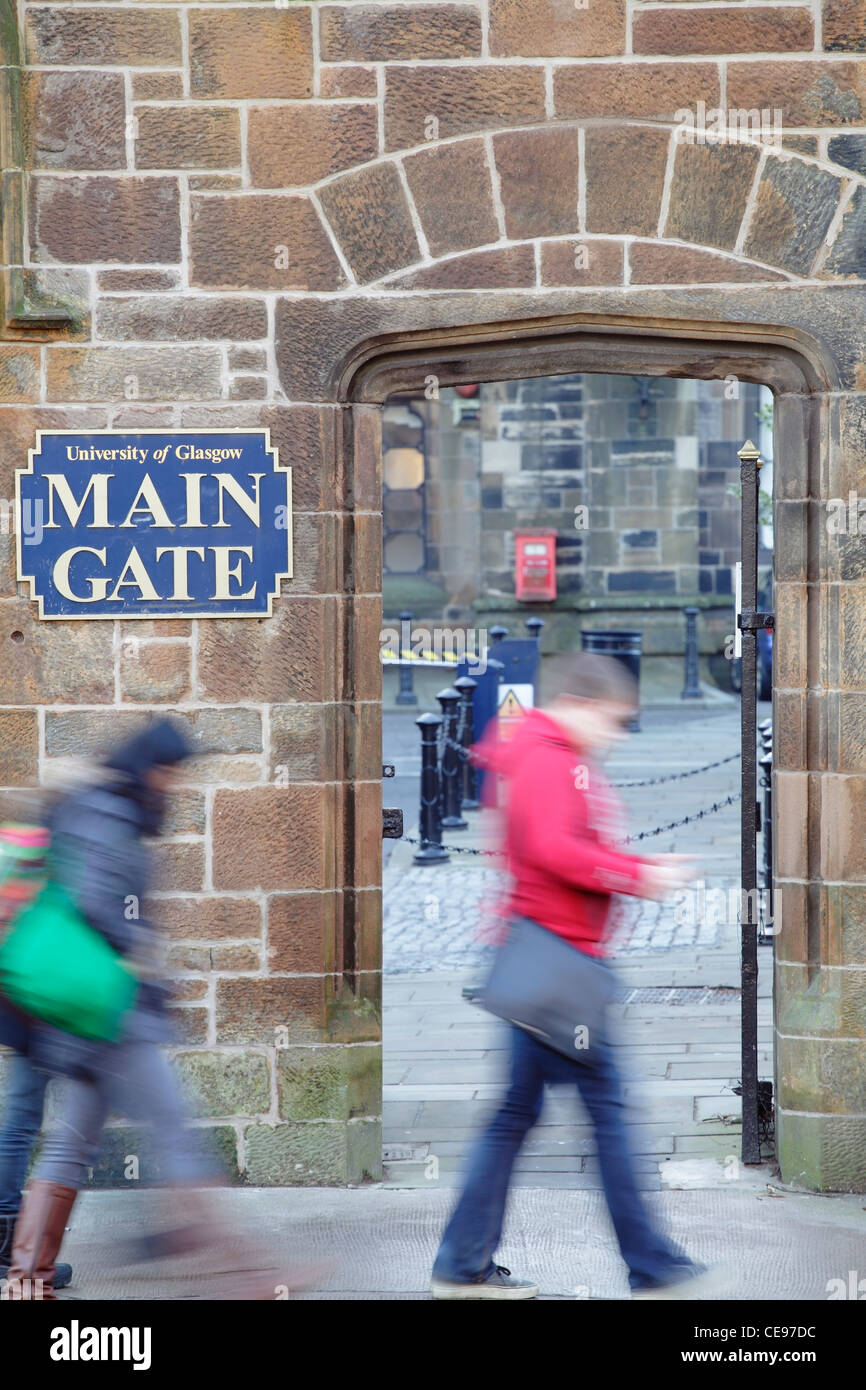 Movimento studenti sfocata passando il cancello principale presso l'Università di Glasgow, Scotland, Regno Unito Foto Stock