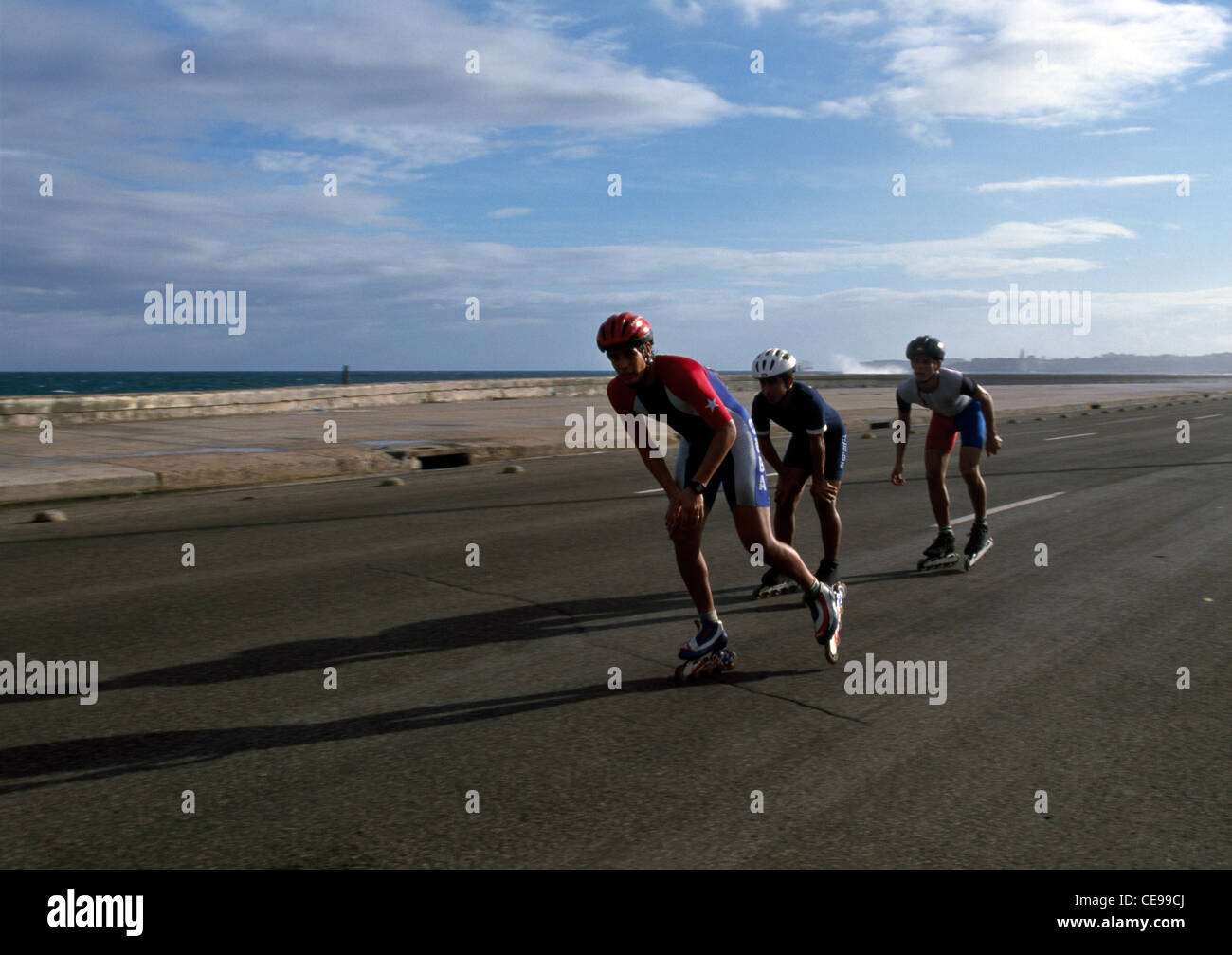 Gli uomini di gara con pattini a rotelle in linea lungo El Malecon a l'Avana, Cuba. Foto Stock