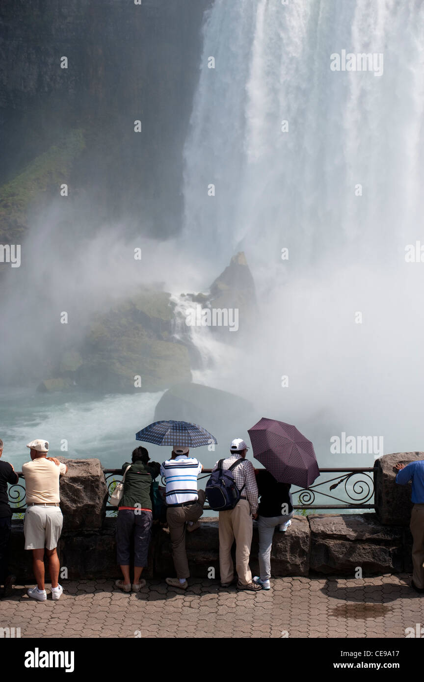 I turisti alla ricerca delle Cascate del Niagara sul versante canadese molti usando ombrello per tenerli asciutti. Foto Stock