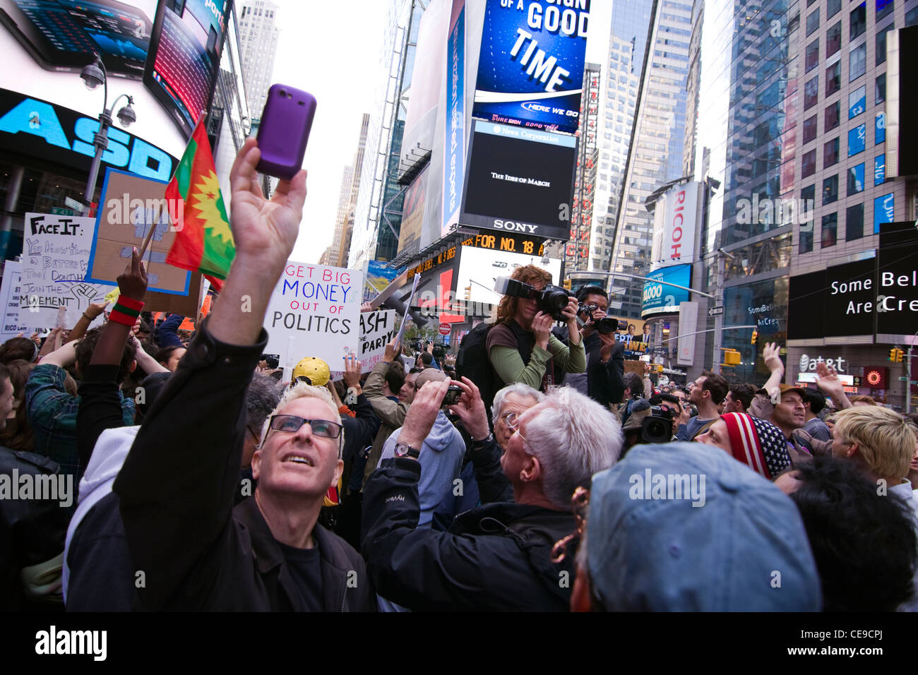 Manifestanti con segni come dilettanti & Fotografi Professionisti documento di occupare Wall Street circolazione, Times Square Ott 15 2011 Foto Stock