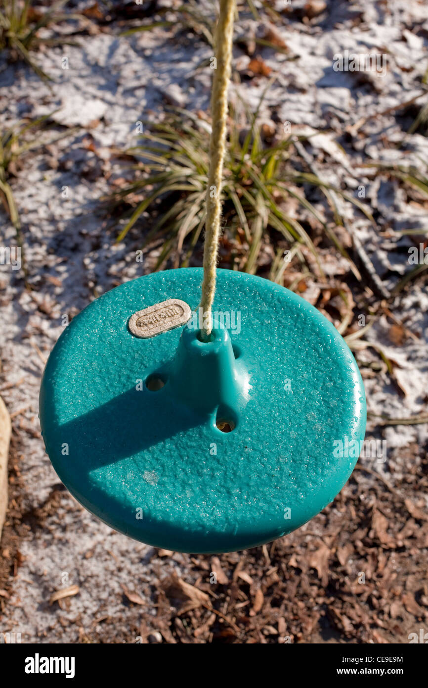 Il verde del sedile in plastica di un bambino in oscillazione la città di Guelph Ontario in Canada. La stagione d'inverno. Foto Stock