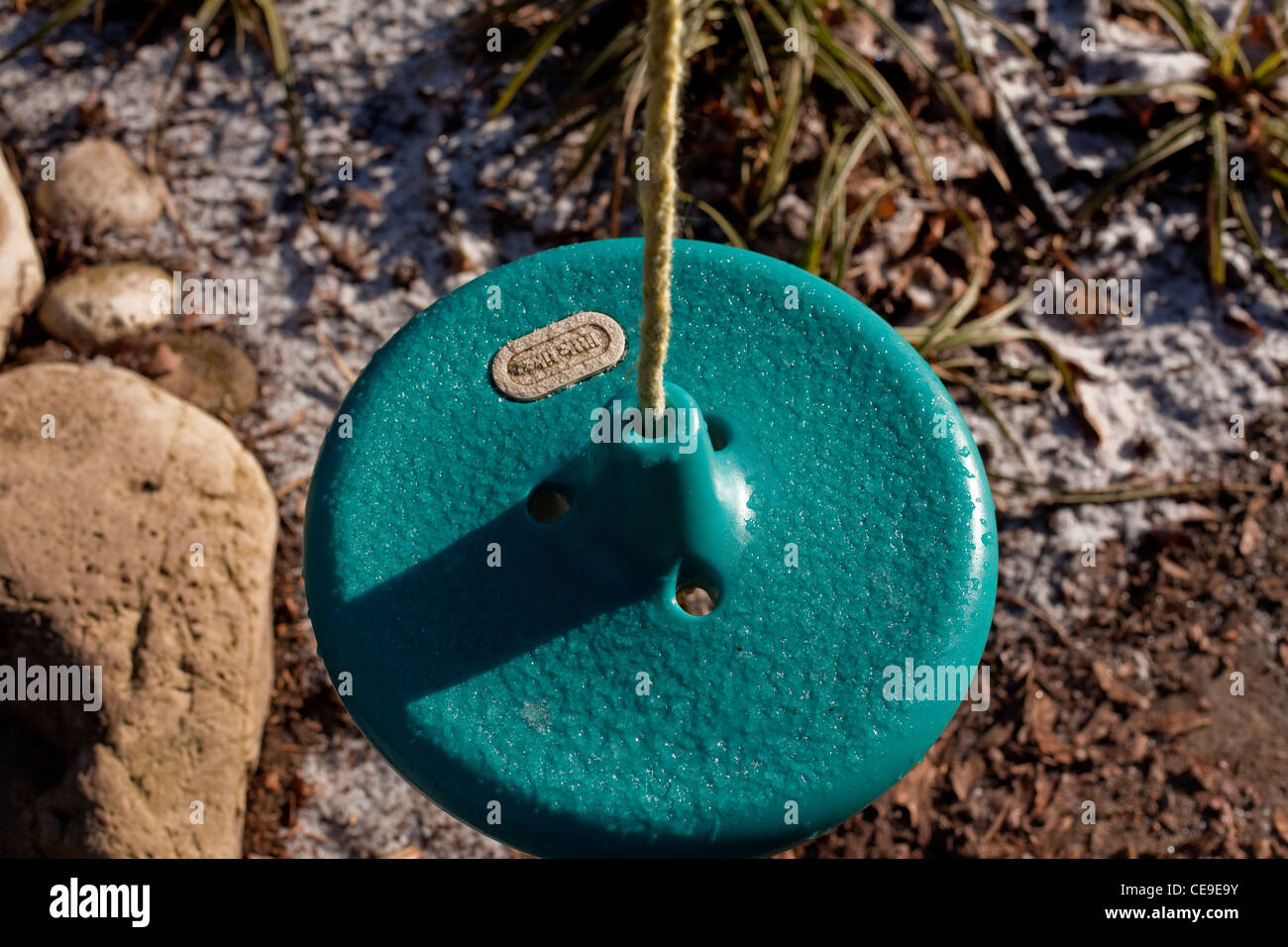 Il verde del sedile in plastica di un bambino in oscillazione la città di Guelph Ontario in Canada. La stagione d'inverno. Foto Stock