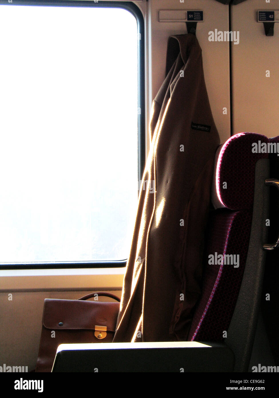 Cappotto e Cartella in pelle in una cabina del treno Foto Stock